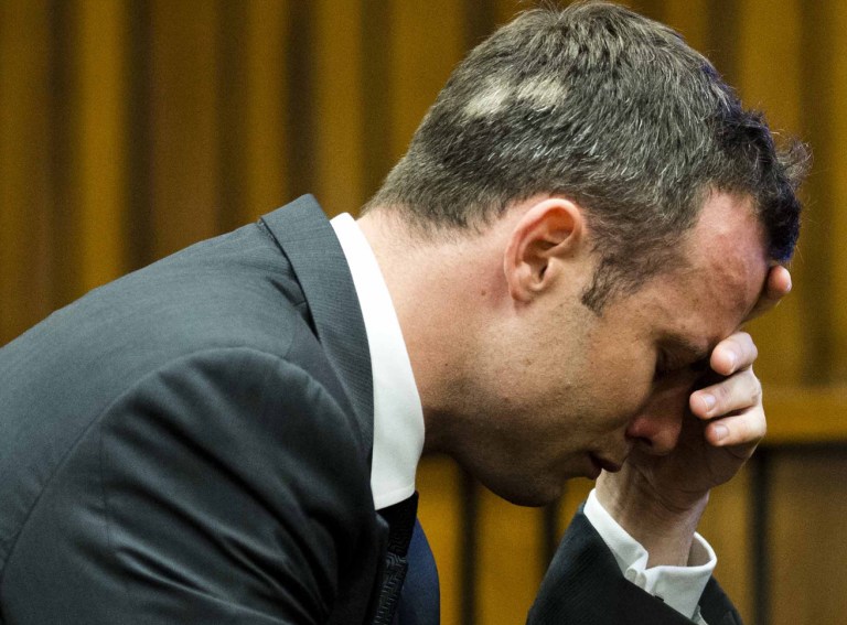 Oscar Pistorius, puts his hand to his face while listening to cross questioning about the events surrounding the shooting death of his girlfriend Reeva Steenkamp, during his trial in Pretoria, South Africa, Friday, March 7, 2014. Pistorius is charged with murder for the shooting death of  Steenkamp, on Valentines Day in 2013. (AP Photo/Theana Breugem, Pool)