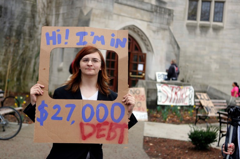 Indiana University senior Randall Burns holds a sign he said represents the average debt a college student has after graduating, during the IU Strike protest, Thursday, April 11, 2013 in Bloomington, Ind. (AP Photo/Bloomington Herald-Times, Jeremy Hogan)