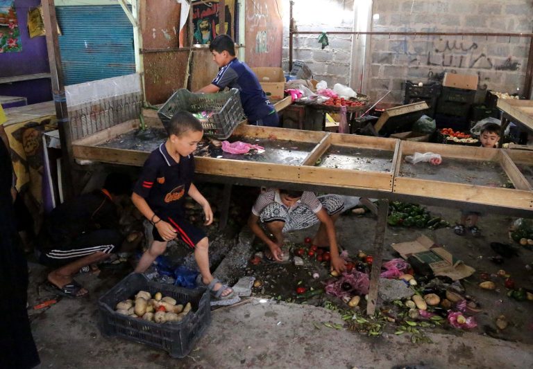 Street vendors collect vegetables after a bomb attack at an outdoor market in Baghdad's Shiite neighborhood of Sadr City, Iraq,Tuesday, May 27, 2014. A suicide bomber set off his explosives-laden belt on Tuesday in a mosque in busy commercial area in central Baghdad, killed and wounded dozens, officials said. (AP Photo/ Karim Kadim)