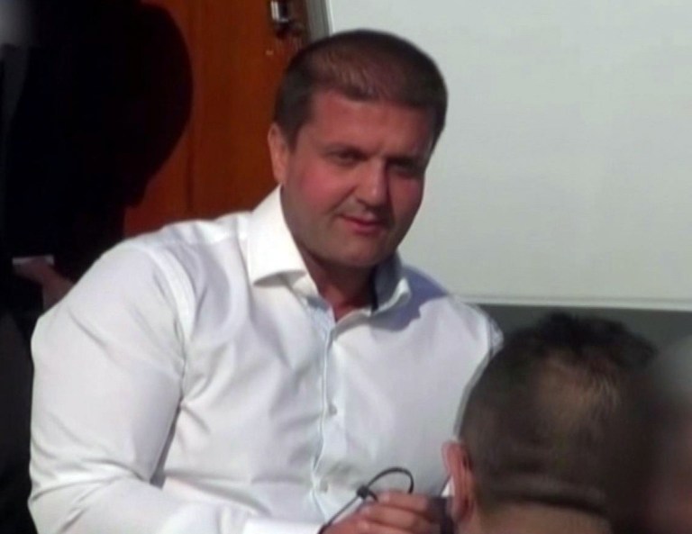In this image taken from video provided by Info Biro TV on Tuesday, March 18, 2014,  Darko Saric is escorted from a government jet, in Belgrade, Serbia, following his arrest in Montenegro. The most wanted suspected drug lord in the Balkans, charged with smuggling 5.7 tons of cocaine from South America to Europe, was arrested Tuesday after surrendering to Serbian authorities, government officials said. The officials said Darko Saric was arraigned after agreeing to surrender unconditionally following his location by several national security agencies in an unidentified Latin American country. (AP Photo/Info Biro TV)