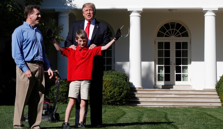 Frank Giaccio, 11, of Falls Church, Va., holds his arms up in the air after being surprised by President Trump while mowing the lawn of the Rose Garden at the White House. (AP Photo/Jacquelyn Martin)