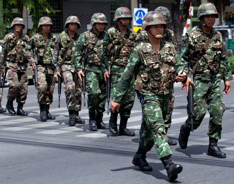 Thai soldiers patrol near the Army Club before former Prime Minister Yingluck Shinawatra arrives to report to Thailand's ruling military in Bangkok, Thailand, Friday, May 23, 2014. The military on Friday summoned the entire ousted government and members of the politically influential family at the heart of the country's long-running conflict, a day after it seized control of this volatile Southeast Asian nation in a non-violent coup. It was unclear why more than 100 people,  including the ousted prime minister and several members of the influential Shinawatra family, were ordered to report to the military, which said it was summoning the high-profile figures 