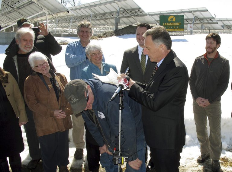 Vermont Gov. Peter Shumlin signs a bill into law on the back of dairy farmer Seth Gardner, Tuesday April 1, 2014, in East Montpelier, Vt. The new law expands Vermont's 