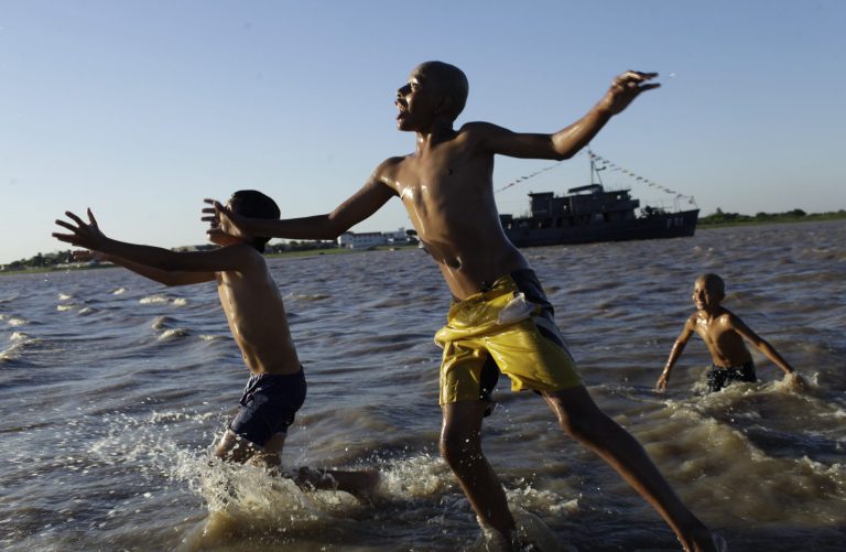   FILE - In this Oct. 14, 2012 file photo, children play in the water in Asuncion Bay, Paraguay. A poll released Wednesday of nearly 150,000 people around the world says seven of the world's 10 countries with the most upbeat attitudes are in Latin America. Gallup Inc. asked about 1,000 people in each of 148 countries last year if they were well-rested, had been treated with respect, smiled or laughed a lot, learned or did something interesting and felt feelings of enjoyment. In Panama and Paraguay, 85 percent of those polled said yes to all five, putting those countries at the top of the list. (AP Photo/Jorge Saenz, File)  
