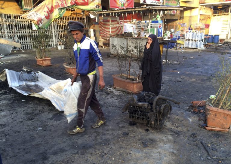 Civilians inspect the aftermath of a car bomb explosion in the morning in Baghdad's eastern neighborhood of Baladiyat, Iraq, Saturday, Oct. 18, 2014. After nightfall Friday, the car bomb exploded near a cafe killing and wounding tens of people, Iraqi officials said. (AP Photo/Khalid Mohammed)