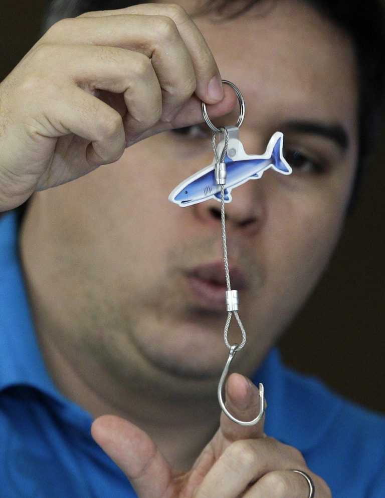   Angelo Villagomez of the PEW Environment Group shows a sample of a line and hook used to catch tuna during a press conference before the opening of the 9th regular session of the Western and Central Pacific Fisheries Commission in suburban Manila, Philippines on Sunday Dec. 2, 2012. Several governments and environmentalists have raised an alarm over destructive fishing methods and overfishing that were threatening the Pacific Ocean's bigeye tuna, the fish popular among sushi lovers the world over. (AP Photo/Aaron Favila)  