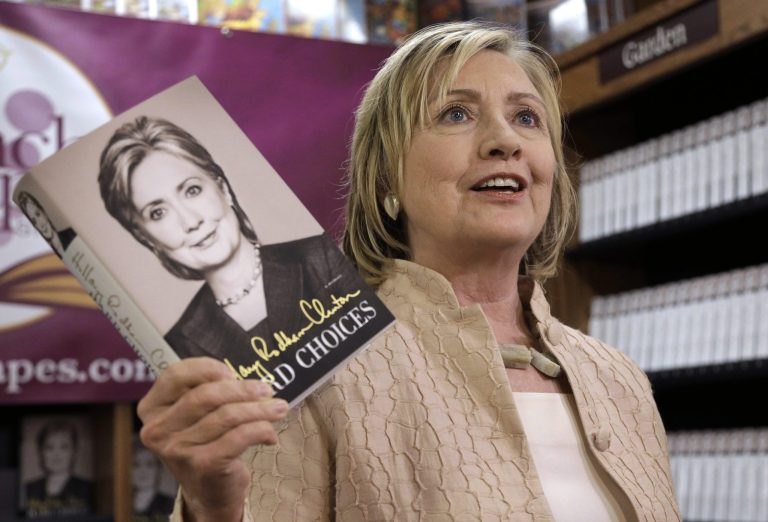 In this Aug. 13, 2014, photo, former Secretary of State Hillary Rodham Clinton holds her memoir 