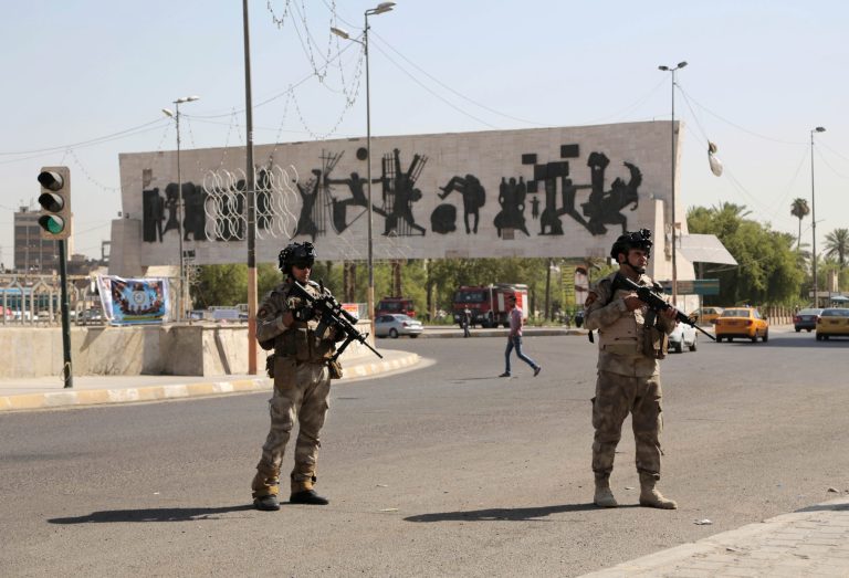 Iraqi army soldiers stand guard at Tahrir Square in Baghdad, Iraq, Monday, June 16, 2014. Sunni militants captured a key northern Iraqi town along the highway to Syria early on Monday, compounding the woes of Iraq's Shiite-led government a week after it lost a vast swath of territory to the insurgents in the country's north. (AP Photo/Khalid Mohammed)