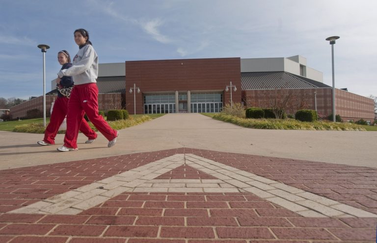 Two students walk past Bud Walton Arena on the University of Arkansas campus. (AP/Beth Hall)
