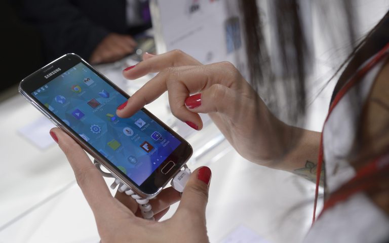 FILE - In this Feb. 25, 2014 file photo, the new Samsung Galaxy S5 is displayed at the Mobile World Congress, the world's largest mobile phone trade show in Barcelona, Spain. The new phone goes on sale Friday, April 11, 2014 around the world, though a few carriers in Korea released them early. Through the major U.S. carriers, it will cost about $200 with a two-year service agreement or $600 to $660 without one. (AP Photo/Manu Fernandez, File)