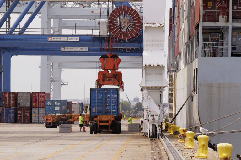   In this Friday, July 13, 2012, photo, a container is loaded onto a ship from China at Massport's Conley Terminal in the port of Boston. The U.S. current account trade deficit narrowed in the July-September quarter to the smallest level since late 2010, but the improvement may not last. (AP Photo/Stephan Savoia)  