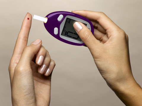Woman using diabetes test kit
