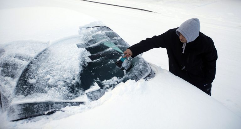 Jose Cardenas scrapes the snow and ice from his windshield as he prepares to go pick up his sister, who didn't feel comfortable driving in the snow in Salem, Ore., Friday, Feb. 7, 2014. Snowfall starting late in the morning Friday will be widespread, dropping a foot or more in mountainous parts of Southern Oregon and 2 to 8 inches in Western Oregon valleys that got slammed Thursday, the National Weather Service said. (AP Photo/Statesman-Journal,  Kobbi R. Blair)