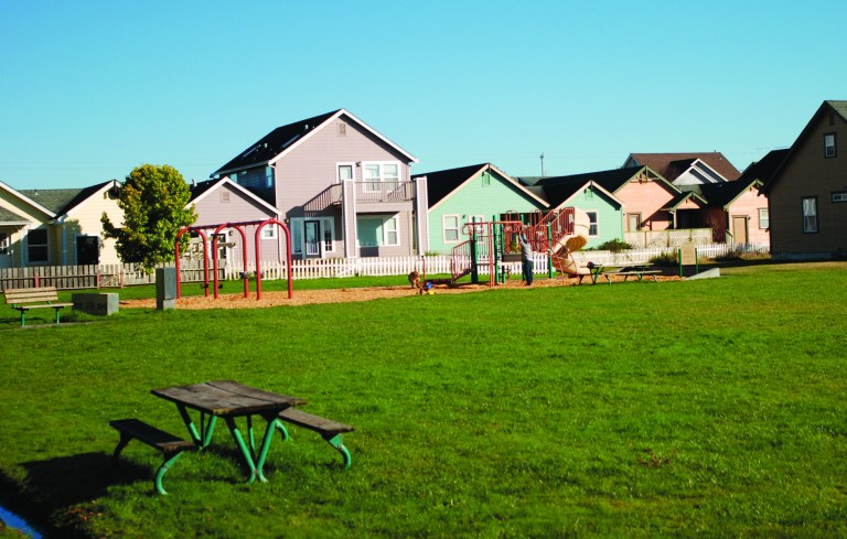 Kids and dogs romp at a playground Oct. 25, 2012 in Arcata, Calif., a half block from a house raided by police on a warrant alleging it was a large-scale indoor marijuana growing operation. Fed up with the proliferation of large-scale indoor growing operations in residential neighborhoods, city officials are asking voetrs to decide on a stiff tax on excessive electricity use designed to drive growers out of town. (AP Photo/Jeff Barnard)