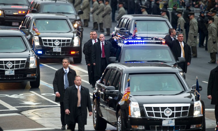 Secret Service Agents stand on the running boards of the limousine carrying President Trump. (AP Photo/Cliff Owen)