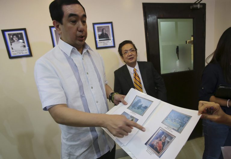 Andres Bautista, head of the Presidential Commission on Good Government, shows reporters some of the rare paintings of European masters that are allegedly part of the collection of the late dictator Ferdinand Marcos as he meets the press in suburban Mandaluyong city, east of Manila, Philippines on Wednesday, Oct. 1, 2014. Bautista says the Philippine government has seized at least 15 paintings from the former home of the Marcos, part of efforts to recover 156 artworks included in his alleged ill-gotten wealth. (AP Photo/Aaron Favila)
