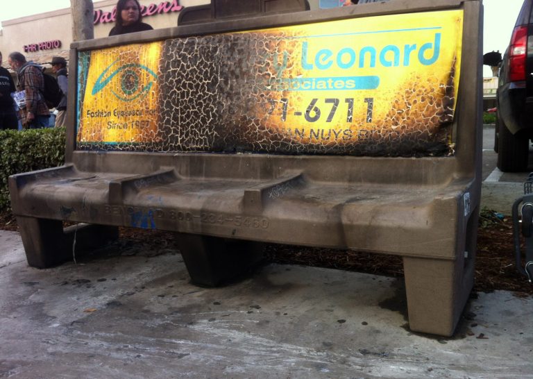   A burned city bus bench seen in the Van Nuys section of Los Angeles on Thursday Dec. 27,2012 after police arrested a man for allegedly setting a 67-year-old woman on fire who was sleeping on the bus stop bench. Authorities said the man, who is in his 20s, was arrested early Thursday. Police said the attack occurred shortly after 1 a.m. outside a drug store. A witness said he saw a man come out of the store and pour something on the woman who had been sleeping on a bench before striking a match and setting her ablaze. The woman, who may be homeless, was taken to a hospital and listed in critical condition. (AP Photo/Greg Risling)  