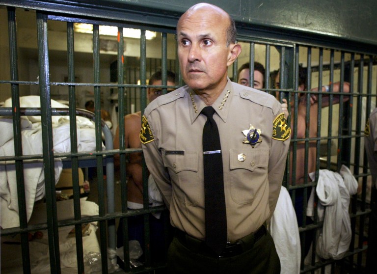 FILE - In this May 19, 2004, file photo, Los Angeles County Sheriff Lee Baca talks with reporters as he leads a tour inside the Men's Central Jail at the Twin Towers Correctional Facility in Los Angeles. A law enforcement official says the embattled sheriff will announce his retirement Tuesday, Jan. 7, 2014. (AP Photo/Damian Dovarganes, File)