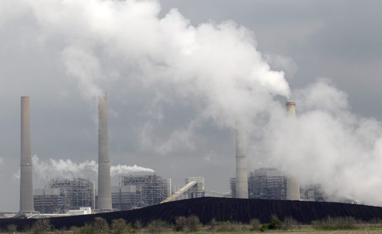   FILE - In this Wednesday, March 16, 2011 file photo, exhaust rises from smokestacks in front of piles of coal at NRG Energy's W.A. Parish Electric Generating Station in Thompsons, Texas. Risking an election-year backlash from Republicans, the Obama administration is proposing new air quality standards to lower the amount of soot that can be released into the air. The move by the Environmental Protection Agency on Friday, June 15, 2012 won immediate support from environmental groups and public health advocates, who said the EPA was protecting millions of Americans at risk of asthma attacks, lung cancer, heart disease and premature death. But congressional Republicans and industry officials called the rules overly strict and said they could hurt economic growth and cause job losses in areas where pollution levels are determined to be too high. (AP Photo/David J. Phillip)  