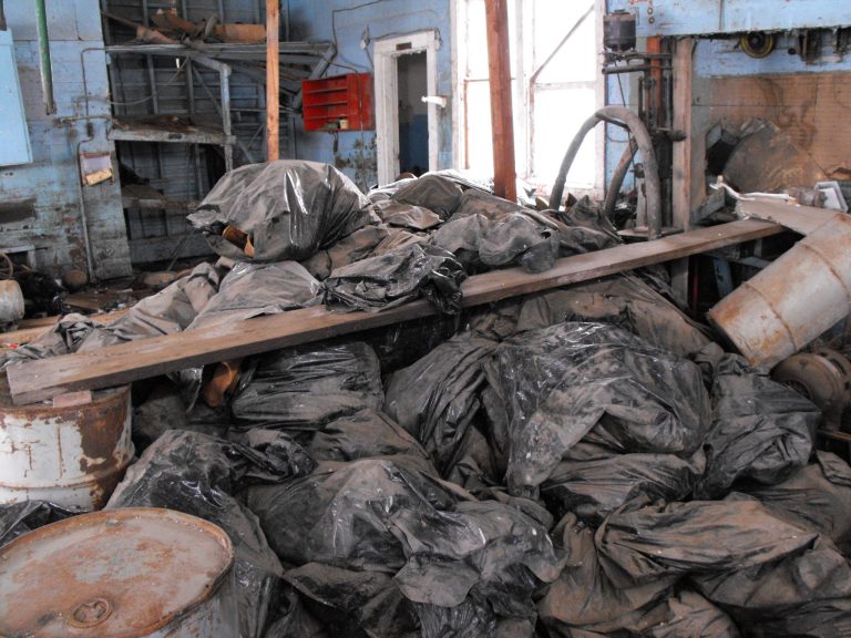 FILE - This March 3, 2014 file photo provided by the North Dakota Health Department are bags full of radioactive oil filter socks, the nets that strain liquids during the oil production process, piled in an abandoned building in Noonan, ND. North Dakota will pay for the cleanup of the illegally dumped radioactive waste, according to  documents obtained Thursday, March, 20, 2014 by The Associated Press shows. (AP Photo/North Dakota Health Department, File)