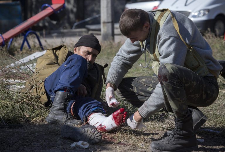 A pro-Russian rebel injured by shrapnel gets a field dressing after action near to the airport in the town of Donetsk, eastern Ukraine Tuesday, Oct. 7, 2014.  Despite a cease-fire declared a month ago between the Ukrainian forces and pro-Russian rebels, the biggest city in eastern Ukraine remains embroiled in fighting . (AP Photo/Dmitry Lovetsky)