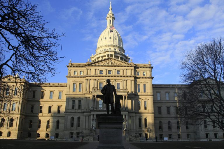   The statue of Gov. Austin Blair, the war governor (1861- 1864), is silhouetted against the state Capitol in Lansing, Mich., Wednesday, Dec. 12, 2012, a day after thousands of protesters rallied on the grounds as lawmakers pushed final versions of right-to-work legislation. (AP Photo/Carlos Osorio)  