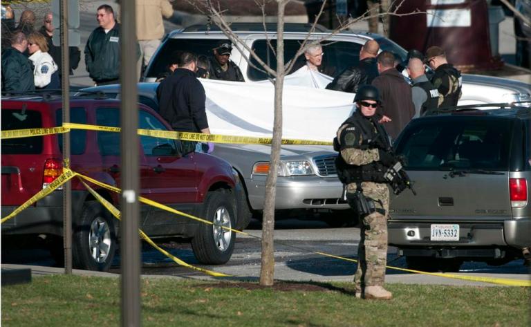 Police officials examine the body of a police officer shot to death in a parking lot on the campus of Virginia Tech, Thursday, Dec. 8, 2011, in Blacksburg, Va. 