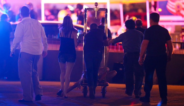 A wounded woman is moved outside the Tropicana during an active shooter situation on the Las Vegas Strip in Las Vegas Sunday, Oct. 1, 2017. Multiple victims were being transported to hospitals after a shooting late Sunday at a music festival on the Las Vegas Strip. (Chase Stevens/Las Vegas Review-Journal via AP)