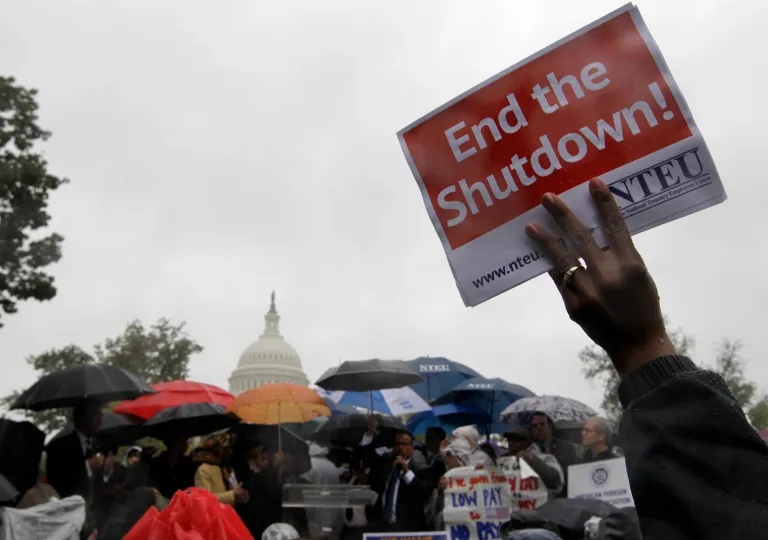 A protester holds up a placard during a rally to end the government shutdown. (AP/ Luis M. Alvarez)