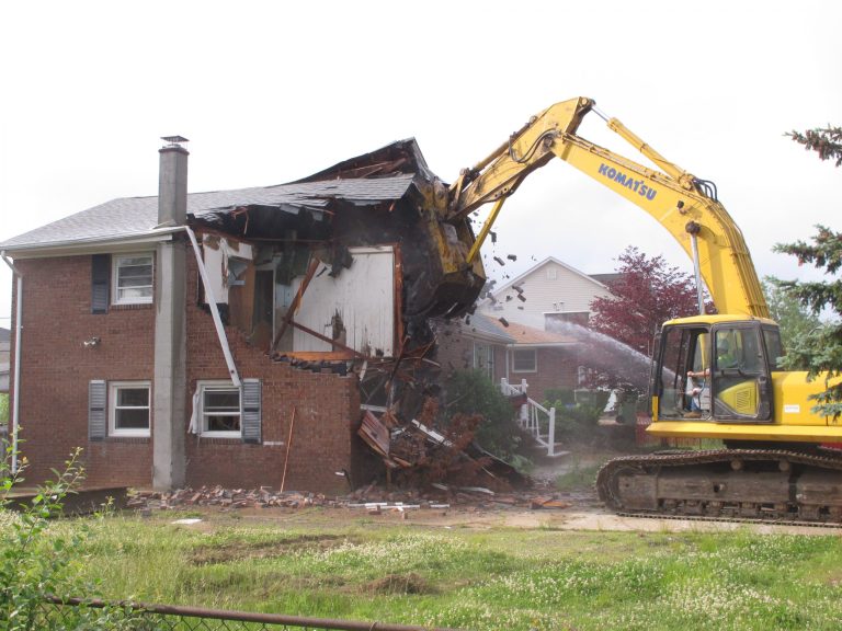 Bricks fly from a home in Sayreville N.J. that was damaged by Superstorm Sandy as it is demolished on June 4, 2014. The work is part of a $300 million program in which New Jersey is buying homes in flood-prone areas and tearing them down to create natural buffers against future storms, and to avoid costly and repetitive repairs to homes that are likely to flood again. (AP Photo/Wayne Parry)