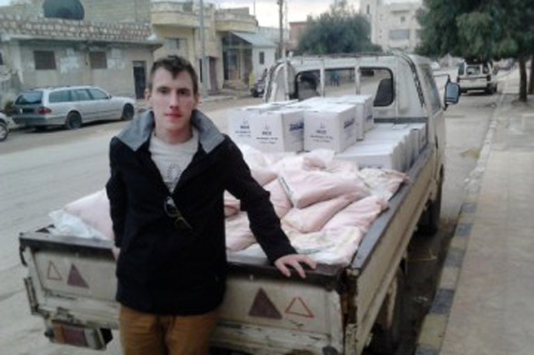 Peter Kassig is shown with a truck loaded with supplies. The Islamic State group released a graphic video on Sunday, Nov. 16, in which a black-clad militant claimed to have beheaded U.S. aid worker Peter Kassig, who was providing medical aid to Syrians fleeing the civil war when he was captured inside Syria on Oct. 1, 2013.