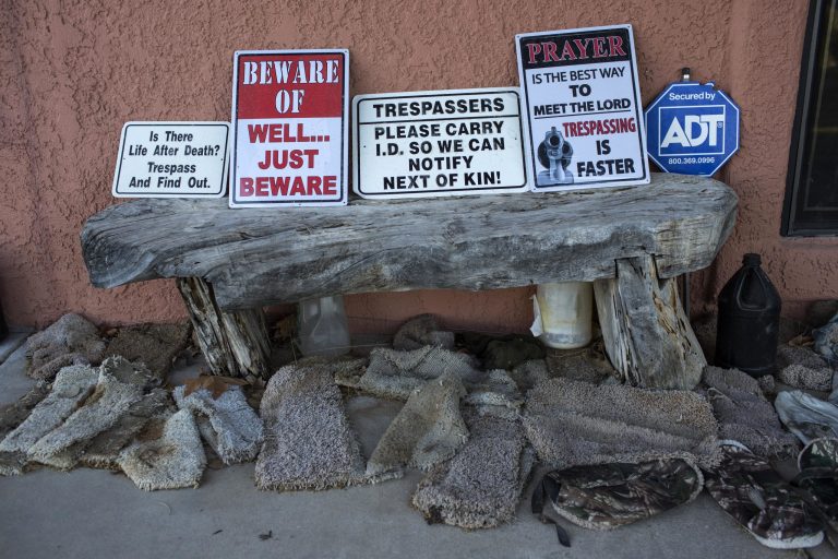 In this Sunday, April 2, 2017 photo, signs warning trespassers line a wooden bench surrounded by makeshift slip-ons known as 