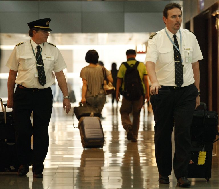 In this  Nov. 30, 2011 photo, two pilots from Cathay Pacific walk in the Hong Kong International Airport in Hong Kong.  The U.S. airline industry will need to hire 1,900 to 4,500 new pilots annually over the next 10 years due to an expected surge in retirements of pilots reaching age 65 and increased demand for air travel, the Government Accountability Office said in the report obtained late Thursday, Feb. 27, 2014. (AP Photo/Vincent Yu, File)