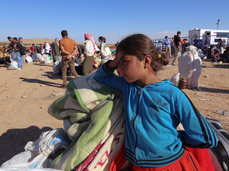 Syrian refugees wait for transport after their arrival at the Turkey-Syria border near Suruc, Turkey, Tuesday, Sept. 30, 2014. U.S.-led coalition airstrikes targeted Islamic State fighters pressing their offensive against a Kurdish town near the Syrian-Turkish border on Tuesday in an attempt to halt the militants' advance, activists said. (AP Photo/Burhan Ozbilici)