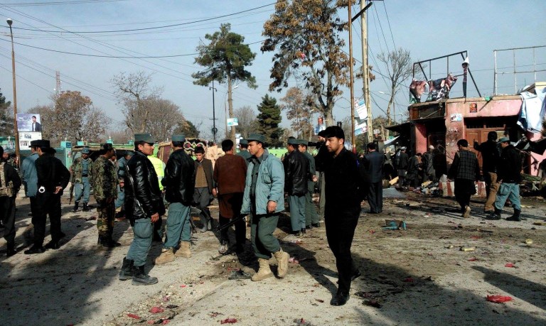 Afghan police forces and civilians inspect the site of a suicide attack in Maymana, capital of Faryab province, Afghanistan, Tuesday, March 18, 2014.  A suicide bomber riding a rickshaw blew himself up outside a checkpoint at a market in northern Afghanistan on Tuesday, killing at least 13 civilians, officials said, in the latest attack in the countdown to presidential elections to be held in less than three weeks. (AP Photo)