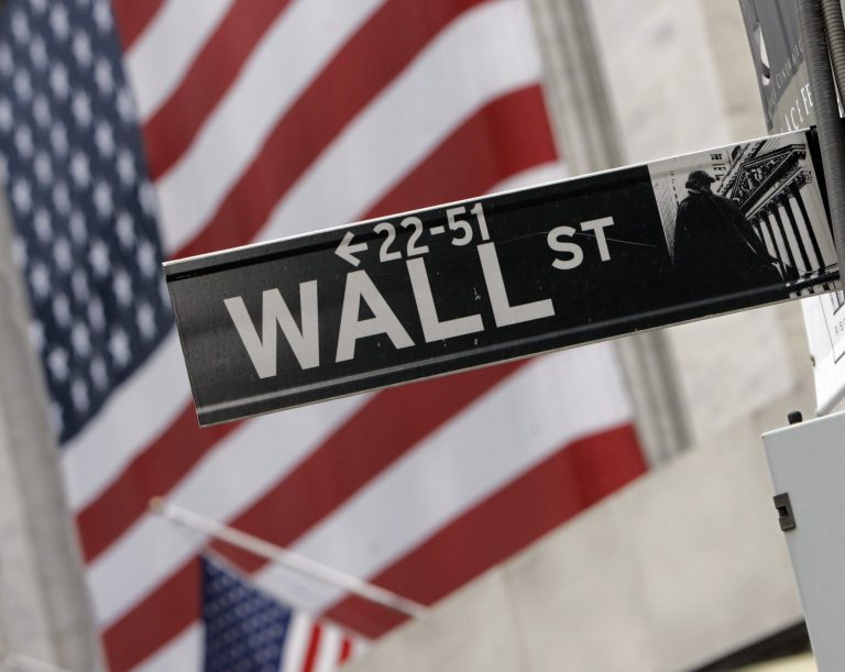 FILE - In this Aug. 16, 2007 file photo, the flags on the facade of the New York Stock Exchange are a backdrop for a Wall Street street sign. European stocks were lower after most Asian markets abandoned modest gains Thursday July 17, 2014 ahead of U.S. economic data and corporate earnings reports. (AP Photo/Richard Drew, file)
