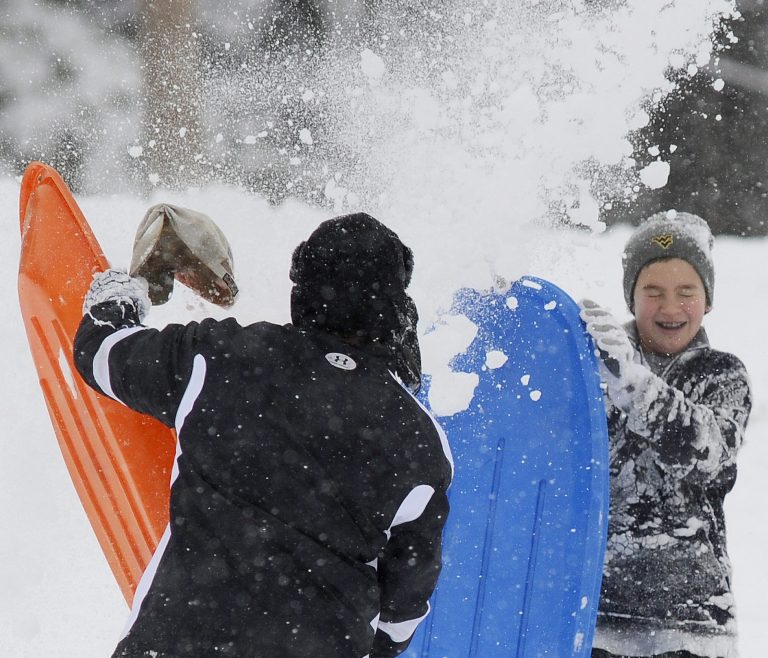 Scott Tyler, left, dumps snow on 13-year-old Blake Hess during a sledding trip Thursday morning, Feb. 13, 2014 at King University in Bristol, Va.   (AP Photo/Bristol Herald Courier, Andre Teague)