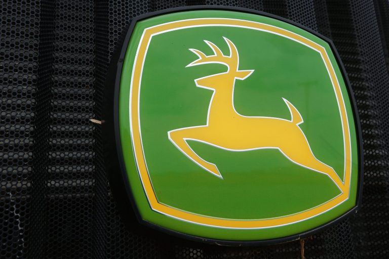 This June 8, 2014 photo shows the John Deere farming logo is seen at a farming equipment dealership in Petersburg, Ill. Deere is laying off about 460 employees indefinitely from an Iowa tractor factory as it continues to adjust to market demand. (AP Photo/Seth Perlman)