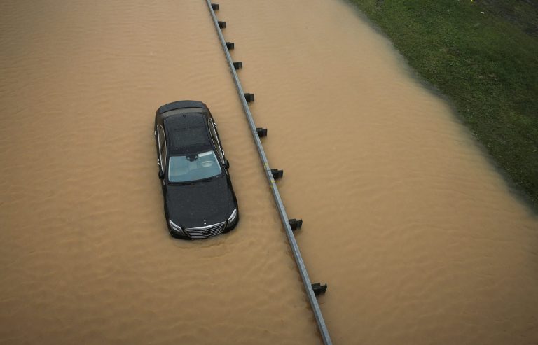 A partially submerged car sits on a flooded section of Interstate 695 in Baltimore, Tuesday, Aug. 12, 2014, after heavy rains fell across the Mid-Atlantic region. Officials shut down the Baltimore beltway in both directions at Quarantine Road due to heavy flooding. (AP Photo/Patrick Semansky)