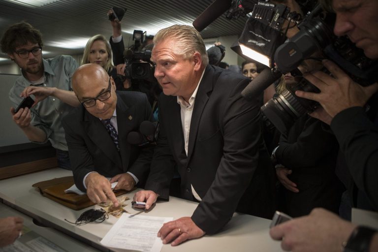 Doug Ford, center, submits his papers to enter the Toronto mayoral race after the withdrawal of his brother, Rob Ford, in Toronto on Friday, Sept. 12, 2014. Mayor Rob Ford withdrew his re-election bid Friday as he seeks treatment for a tumor in his abdomen, ending a campaign he had pursued despite a stint in rehab and persistent calls for him to quit amid drug and alcohol scandals. (AP Photo/The Canadian Press, Chris Young)