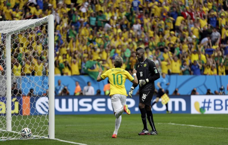 Brazil's Neymar runs past Cameroon's goalkeeper Charles Itandje after scoring his side's first goal during the group A World Cup soccer match between Cameroon and Brazil at the Estadio Nacional in Brasilia, Brazil, Monday, June 23, 2014. (AP Photo/Natacha Pisarenko)