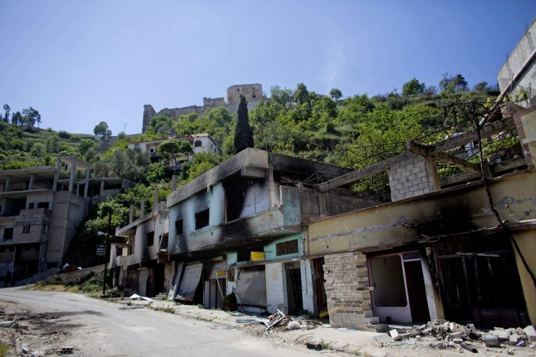 This photo made on Thursday, May 1, 2014, shows Crac des Chevaliers, top center, the world's best preserved medieval Crusader castle, above the destroyed Sunni village of Hosn in Syria. The village was destroyed in fighting between the government and rebel forces while the castle, listed as a UNESCO world heritage site, also has been damaged over the past two years. (AP Photo/Dusan Vranic)