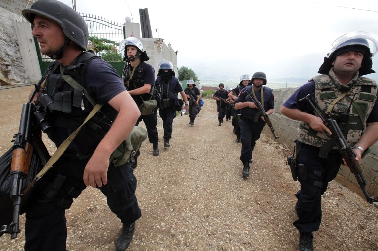 Albanian police enter the lawless village of Lazarat, 230 kilometers (140 miles) south of capital Tirana, wendesday, June 18, 2014, combing houses for drugs. Near-continuous gunfire rings out from the lawless village as hundreds police still battle well-armed marijuana growers trying to thwart a government crackdown. (AP Photo/Hektor Pustina)
