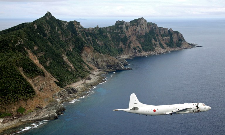 FILE - In this Oct. 13, 2011 file photo, Japan Maritime Self-Defense Force P-3C Orion surveillance plane flies over the disputed islands, called the Senkaku in Japan and Diaoyu in China, in the East China Sea. Japan says it will give names to five uninhabited islands as part of a group in the East China Sea, Friday Aug. 1, 2014, a move likely to spark anger from other claimants China and Taiwan. (AP Photo/Kyodo News, File) JAPAN OUT, CREDIT MANDATORY