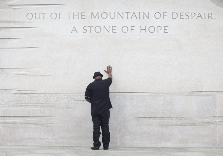   Rev. Bobby Turner or Columbus, Ohio, places his hand on the Martin Luther King Jr. Memorial, Thursday, Aug. 22, 2013, in Washington. President Barack Obama is scheduled to speak at a ceremony on the 50th anniversary of the 1963 March on Washington. (AP Photo/Carolyn Kaster)  