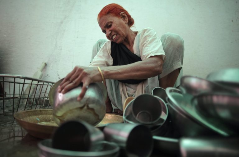   In this May 10, 2012 photo, Fatima Munshi, working as domestic help, cleans dishes in Khandwa, India. Saroo Brierley, 30, was reunited with his biological mother, Munshi, in February 2012, 25 years after an ill-fated train ride left him an orphan on the streets of Calcutta. (AP Photo/Saurabh Das)  
