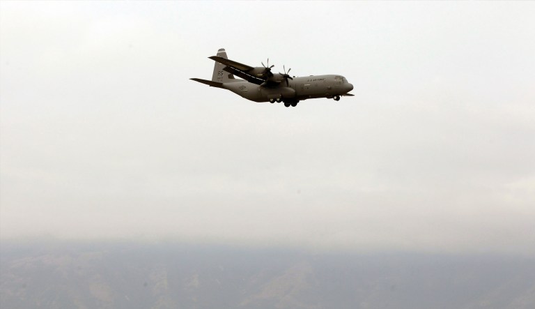 Sixteen people were believed to be aboard the plane in Mississippi, 12 of them confirmed dead. A C-130 military transport plane, in the same style as the one that crashed in Mississippi, flies in the distance.