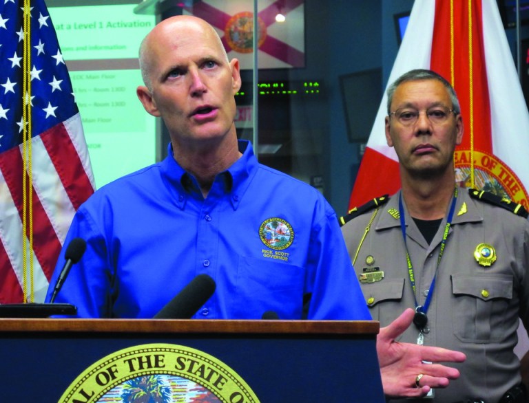 Florida Gov. Rick Scott announces a state of emergency for most of Florida's Gulf coast due to heavy rains and flooding caused by Tropical Storm Debby during a news conference at the State Emergency Operations Center in Tallahassee, Fla. Col. David Brierton, commander of the Florida Highway Patrol, right, listens. Tropical Storm Debby drenched Florida with heavy rains, flooded low-lying neighborhoods and knocked out power to thousands of homes and businesses as it lingered off the state's coast Monday. (AP Photo/Bill Cotterell)