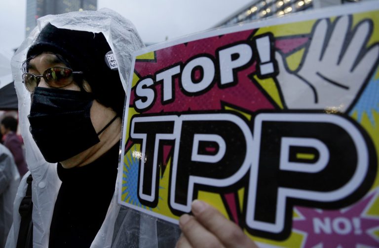 A protester holds a placard during a rally against the Trans-Pacific Partnership (TPP) in Tokyo, Tuesday, April 22, 2014. In Japan and elsewhere, there are concerns over making politically difficult market-opening concessions without reassurance that Obama will have the 