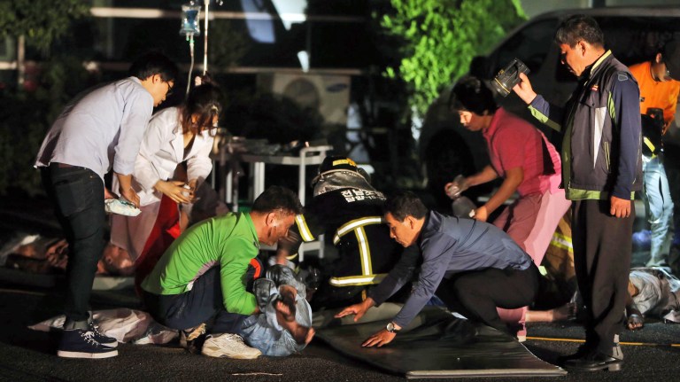 Rescue workers treat victims of a major fire at a hospital in Jangseong, South Korea, Wednesday, May 28, 2014.  South Korean officials said at least 20 patients and one nurse died in a fire at a hospital in the southwestern city of Jangseong. (AP Photo/Yonhap, Hyung Min-woo)  KOREA OUT